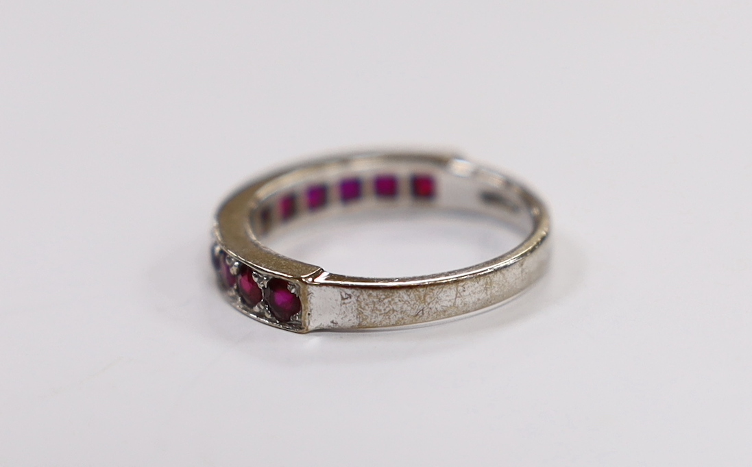 An 18ct white gold and eleven stone ruby set half eternity ring, size L, gross weight 3.8 grams.